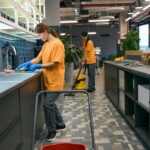 Team young women doing spring cleaning in kitchen area coworking space