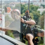 industrial-mountaineering-worker-cleaning-window-outside-building-.jpg