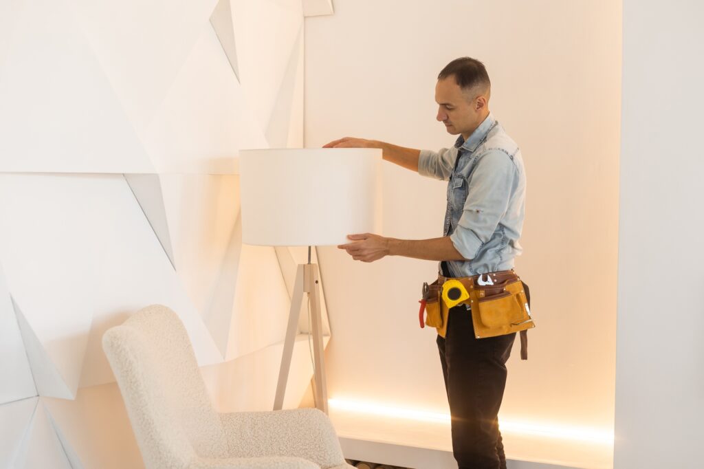 Male Electrician Repairing Light floor lamp
